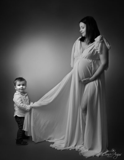 Moment complice entre une femme enceinte et son aîné lors d’une séance photo de grossesse en studio à Pontenx-les-Forges