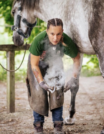 Photo d’Harmony Sauvrezy, maréchale ferrante à Mimizan, en plein travail, illustrant son expertise et sa passion pour le soin des chevaux