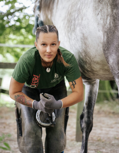 Photo d’Harmony Sauvrezy, maréchale ferrante à Mimizan, en plein travail, illustrant son expertise et sa passion pour le soin des chevaux