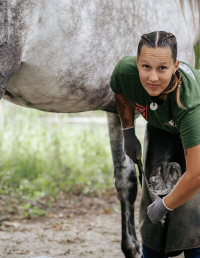 Photo d’Harmony Sauvrezy, maréchale ferrante à Mimizan, en plein travail, illustrant son expertise et sa passion pour le soin des chevaux