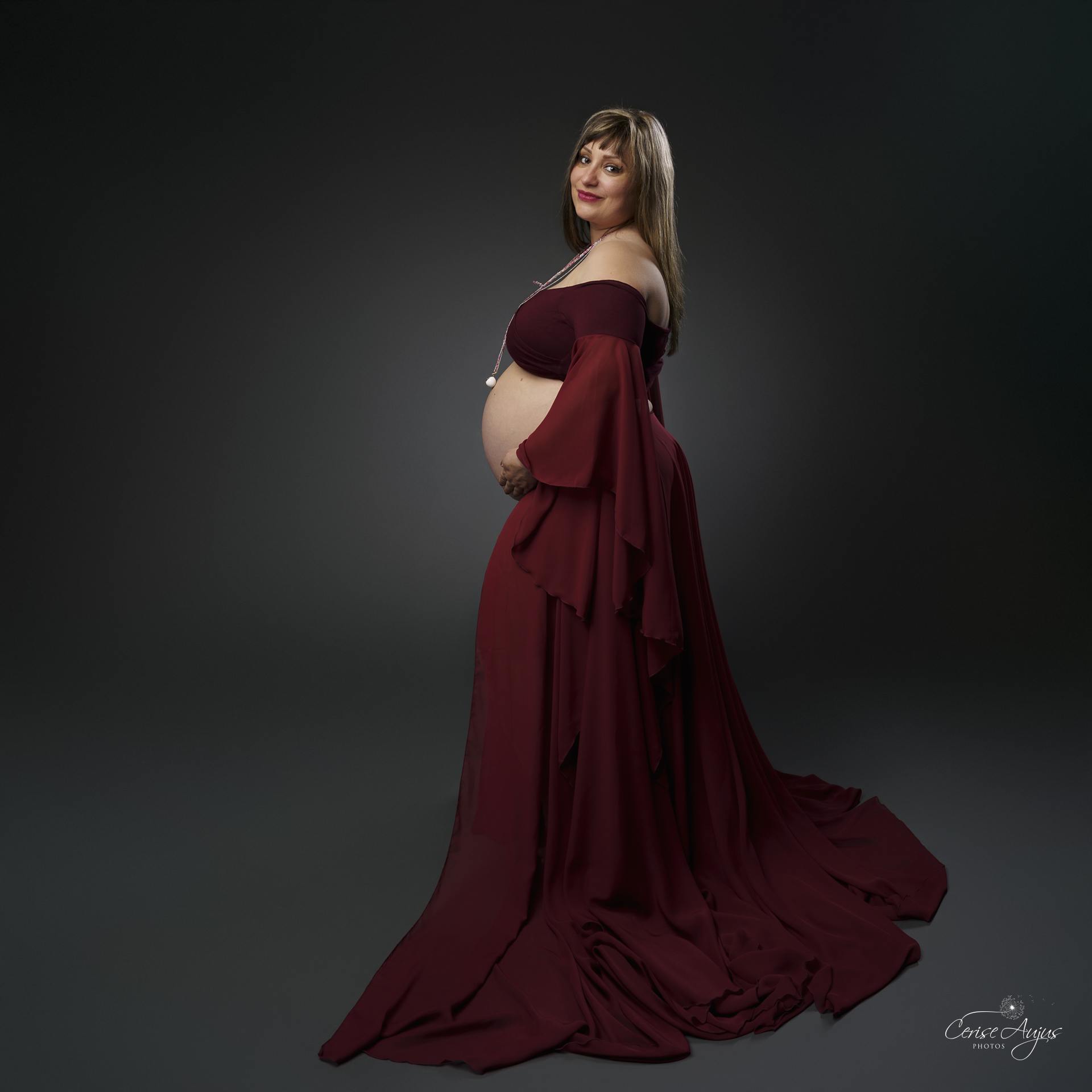 Future maman regardant son ventre rond séance photo grossesse Mimizan douceur maternité bébé arc-en-ciel