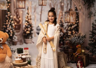 Photographe Noël Landes, décor Le Sentier Enchanté, enfant tenant des skis en bois en studio à Pontenx-les-Forges